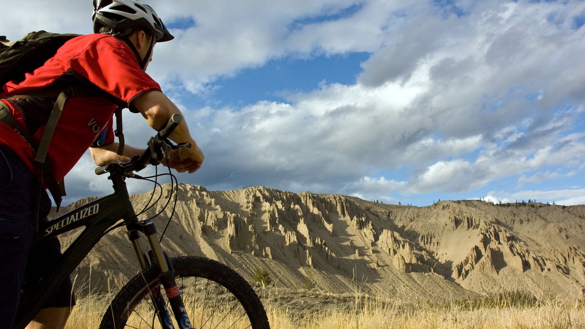 Riding the rim trail above Farwell Canyon, sandstone hoodoos below and big sky above